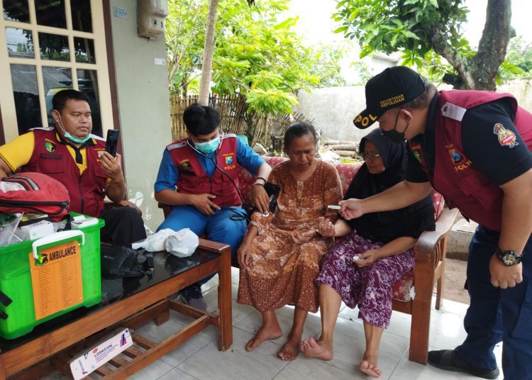 Petugas Size Dokes Polresta Banyuwangi ketika melayani warga Sutri, Kelurahan Sobo yang mengeluh sakit, Selasa (18/10/2022) (F: blok-a.com/Kuryanto)