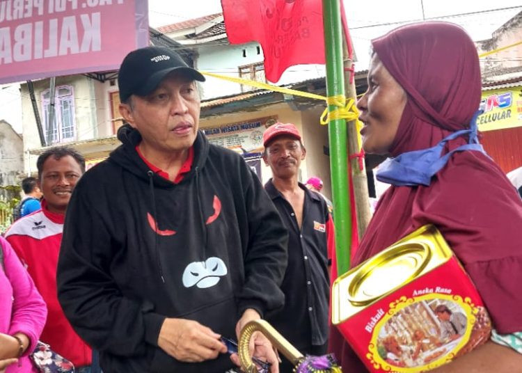 Anggota Komisi D DPRD Provinsi Jatim Fraksi PDI Penjuangan, Martin Hamonangan ketika menyerahkan bantuan kepada warga yang terdampak banjir Kalibaru, bertempat di Posko Peduli Banjir Kalibaru, Minggu (6/11/2022), siang. (blok-a.com/Gatut Imawan)
