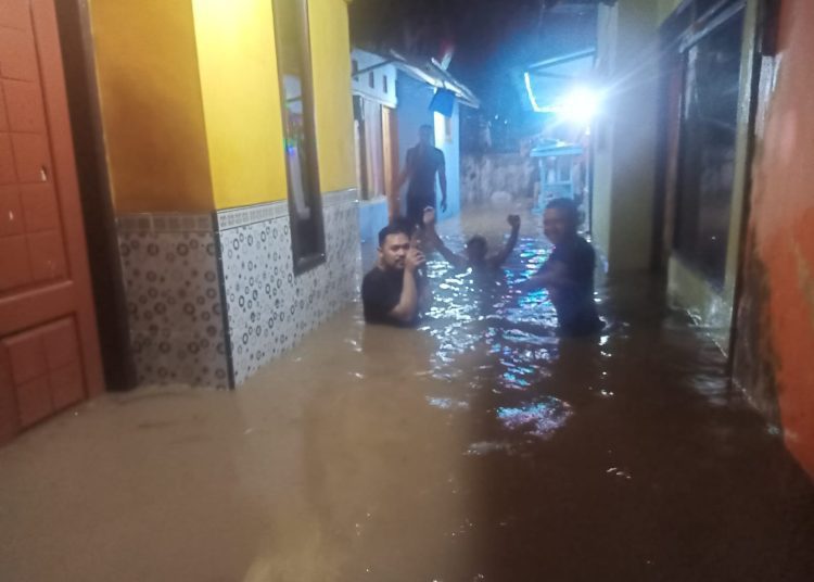 Warga Kampung Ujung, Kelurahan Kepatihan didepan rumahnya yang terendam banjir, Senin (28/11/2022)  (blok-a.com/Aras Sugiarto)