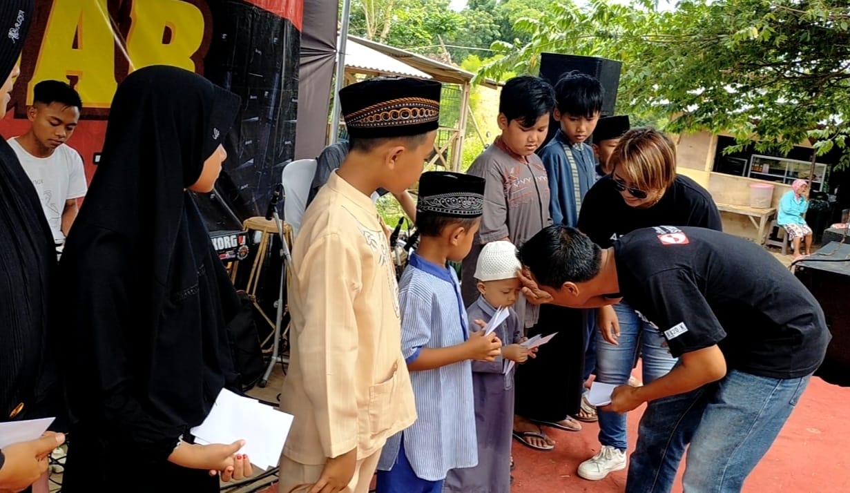 Kades Genteng Kulon saat memberikan sambutan di depan seluruh tamu undangan dan pembagian santunan yang dilakukan oleh tamu undangan kepada anak yatim.