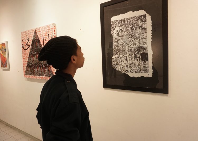 Caption: Chodir sedang memandangi karya seni nya di pameran Menyerang Kota di DKM Kota Malang, Senin (9/1/2023) (blok-a/helen)