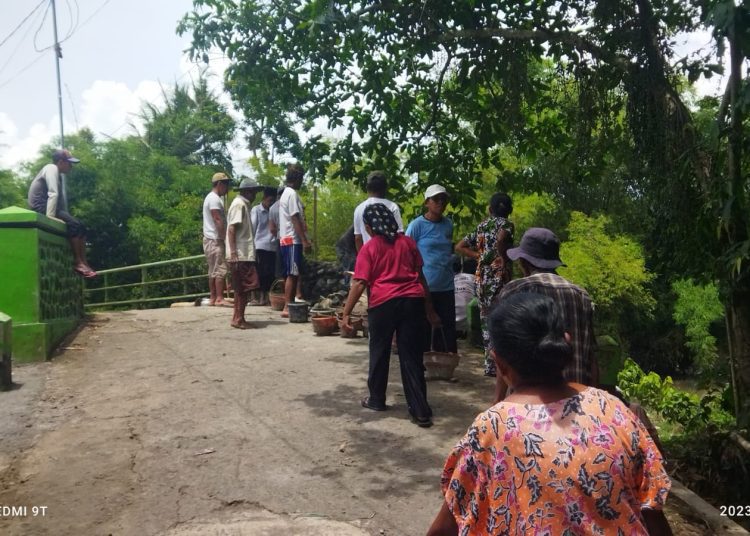Warga Desa Patemon, Kecamatan Pakusari, Jember bergotong royong melakukan perbaikan jembatan, Rabu (25/1/2023). (blok-a.com/Yasir)