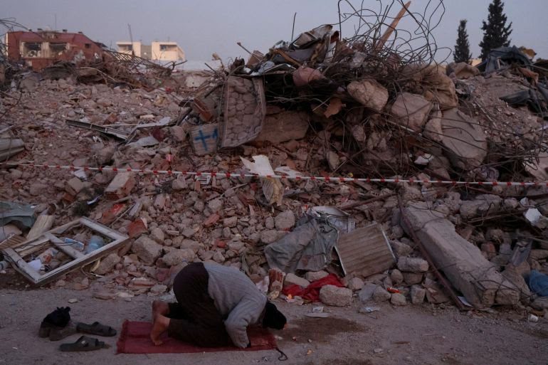 Seorang pria berdoa di dekat puing-puing rumah yang hancur setelah gempa bumi di Kahramanmaras [Nir Elias / Reuters]