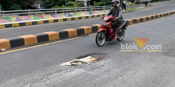 Caption: Jalan berlubang di Jl. Mayjen Sungkono, Jembatan Kedungkandang, Senin (13/2/2023). (blok-a/Helen)