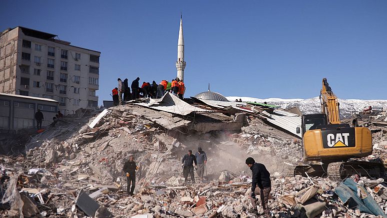 Orang-orang bekerja di lokasi bangunan yang runtuh, setelah gempa mematikan di Kahramanmaras, Turki 8 Februari 2023. (Reuters)