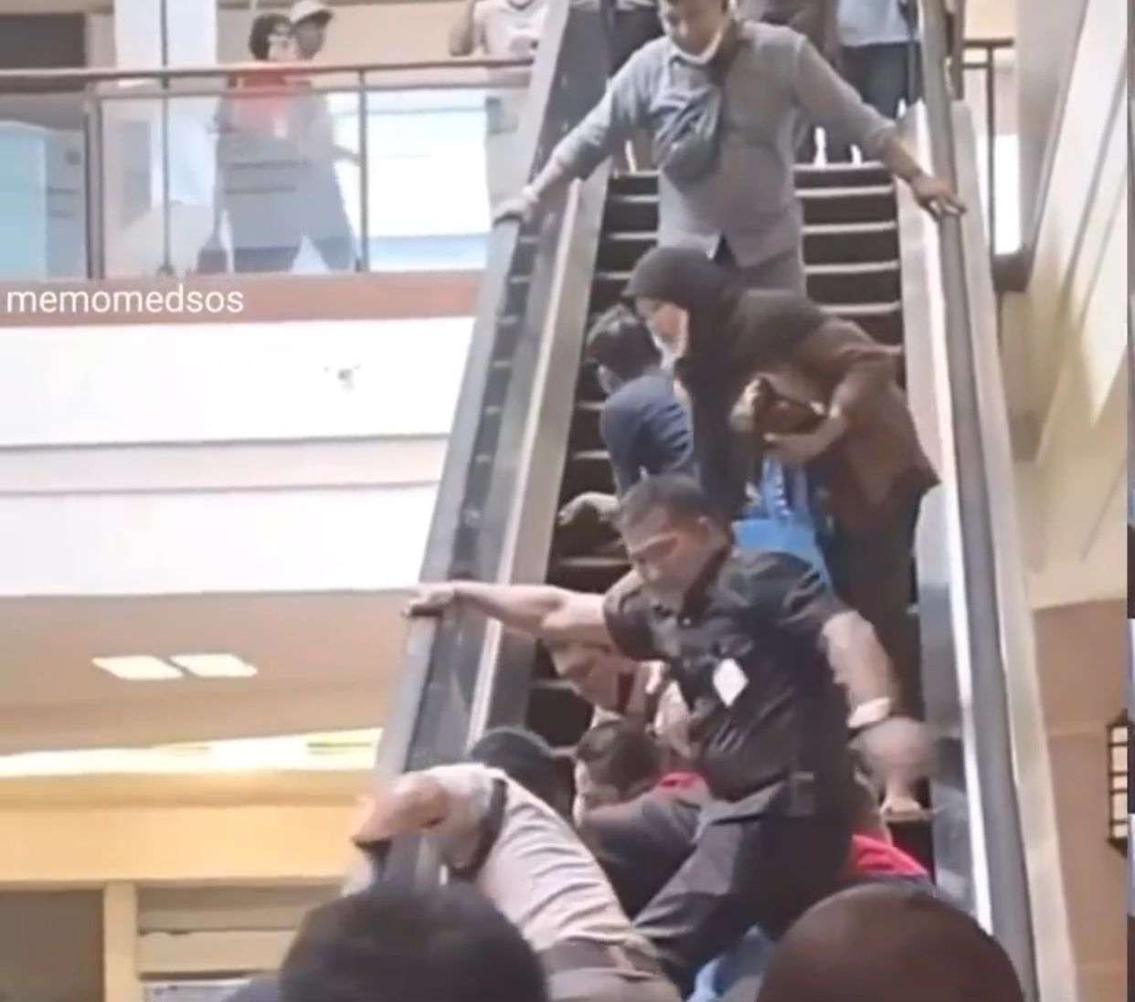 Caption : Tangkapan layar akun @memomedsos saat memperlihatkan seorang satpam dan pengguna eskalator sedang memisahkan tangan balita yang terjepit pada bagian tepi eskalator.