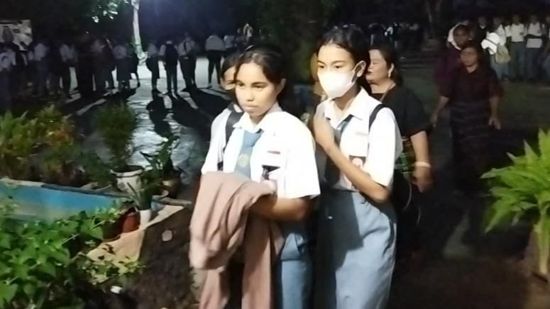Para siswi kelas XII SMAN 6 Kupang berbaris menuju kelas usai mengikuti upacara di tengah lapangan yang gelap, Selasa (28/02).(BBC/PUTRA FERNANDUS)