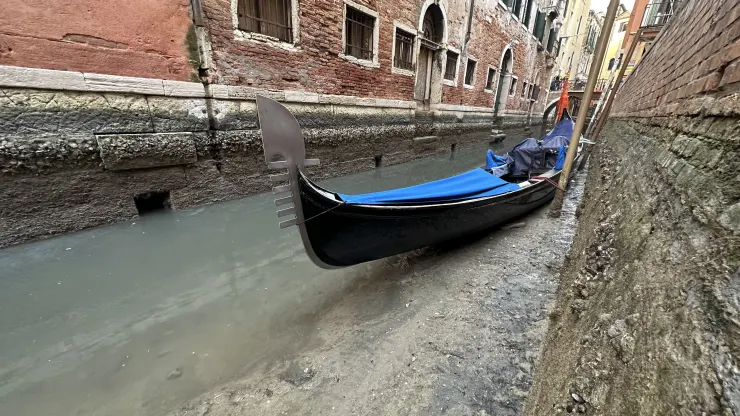 Gondola merapat di kanal kering selama air surut di Venesia, Italia, Senin, 20 Februari 2023. (Luigi costantini/AP)