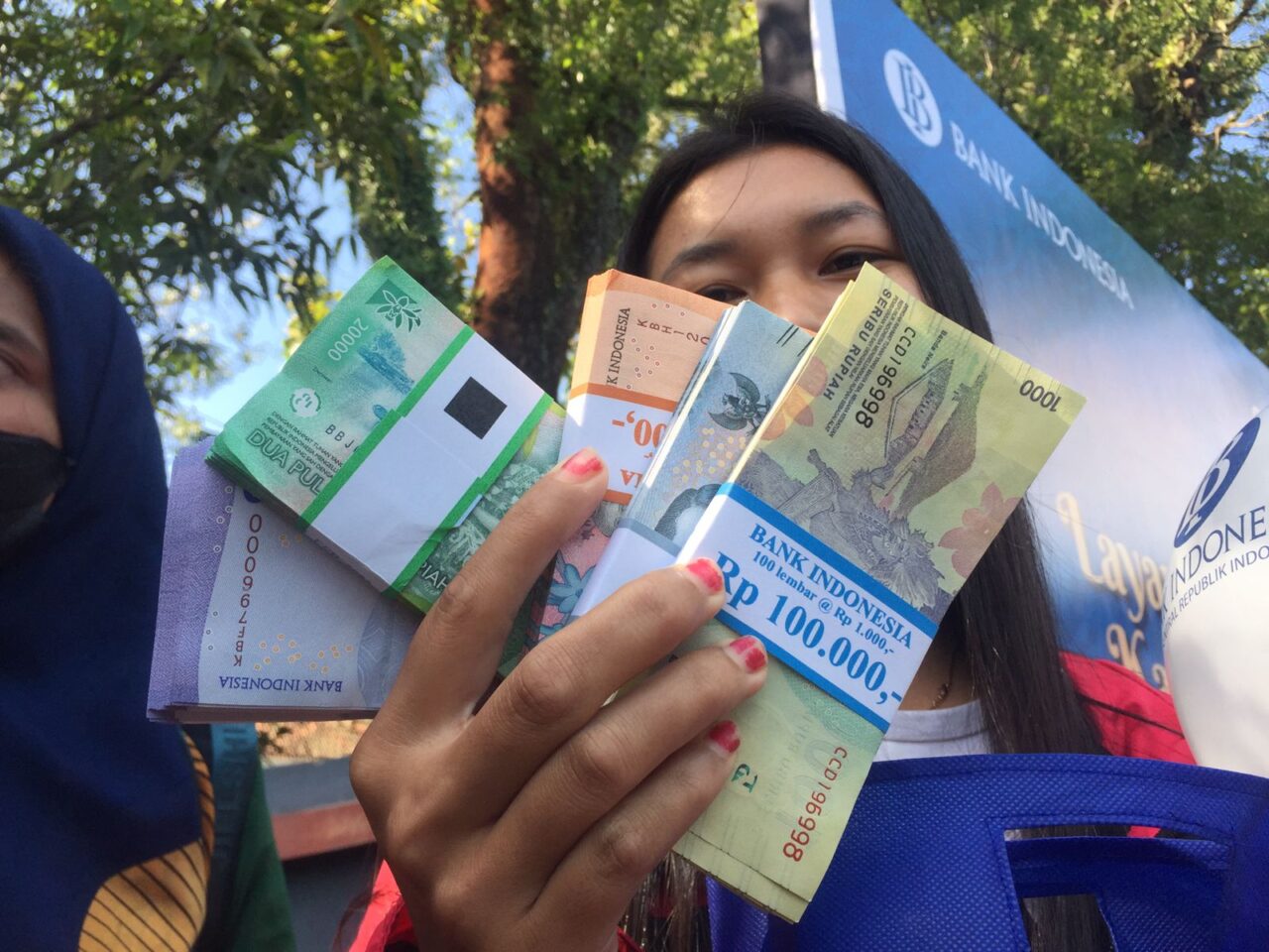 Winsa Wiwin (28) warga Kota Malang yang berhasil mendapatkan nomor urut pertama pada penukaran uang di Bank Indonesia Cabang Malang. (Blok-a.com/Putu Ayu Pratama S)