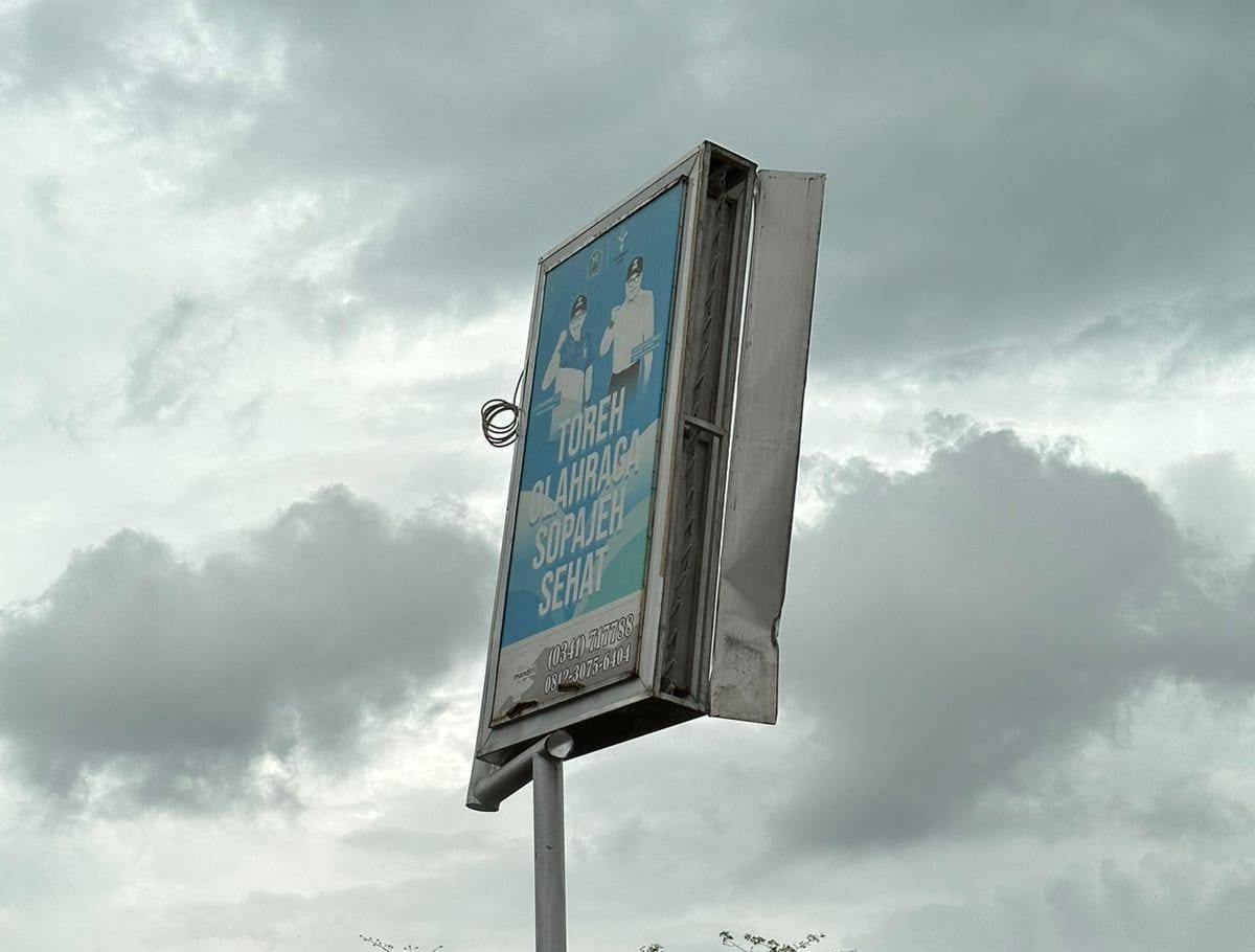 Caption : Papan iklan miring meresahkan pengendara di Jembatan kedungkandang (Sumber : blok a.com/mike)