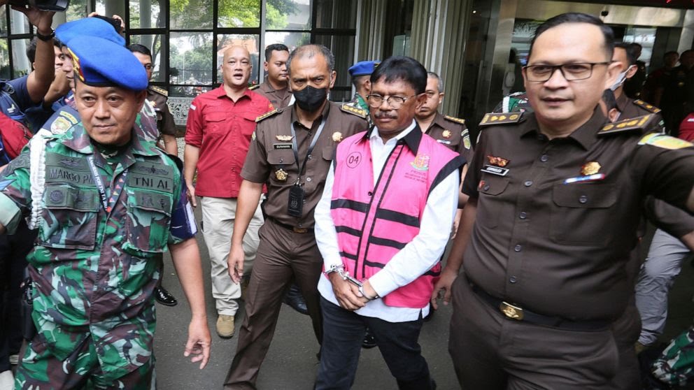 Menkominfo Johnny G Plate mengenakan rompi tahanan khas Kejagung berwarna pink di Lobi Gedung Bundar Kejagung, Jakarta, Rabu (17/5/2023). (AP Photo)