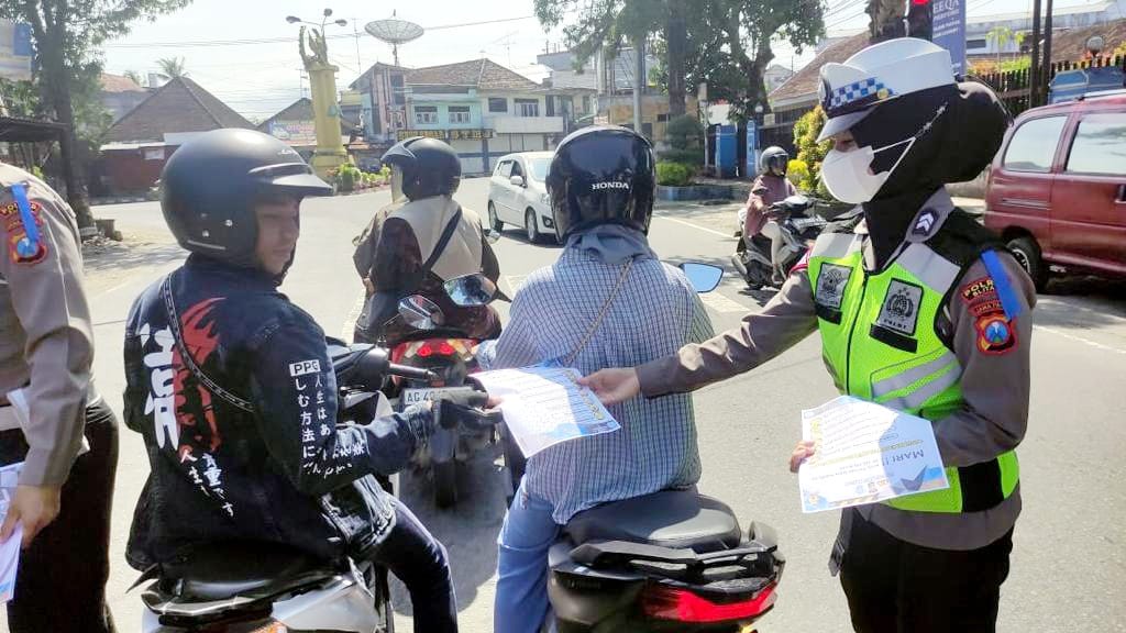 Satgas Preemtif Dikmas Lantas Polres Blitar, juga membagikan brosur dan leaflet berisi informasi tentang aturan lalu lintas yang harus dipatuhi. (dok. Humas Pilres Blitar)