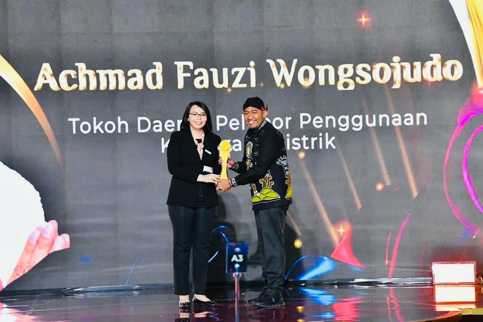 Lagi, Bupati Sumenep Sabet Penghargaan Pelopor Penggunaan Motor Listrik Sumenep, blok-a.com - Setelah sebelumnya Bupati Sumenep meraih penghargaan sebagai tokoh penggerak penggunaan motor listrik dari Lembaga Prestasi Indonesia Dunia (LEPRID). Kini ia kembali menyabat penghargaan sebagai pelopor penggunaan motor listrik, Kamis (21/9/2023) di Hotel Westin Jakarta, . Penghargaan itu diberikan oleh Detikcom Awards kepada Bupati Sumenep Achmad Fauzi dengan kategori Tokoh Daerah Pelopor Penggunaan Kendaraan Listrik. Bupati Fauzi dianggap ikut berkontribusi menurunkan polusi. Fauzi dinilai sukses memgkampanyekan penggunaan motor listrik di Kabupaten Sumenep khususnya sebagai kendaraan ramah lingkungan. Sehingga hal itu mendorong masyarakat beralih ke kendaraan listrik dari sebelumnya berBahan Bakar Minyak (BBM). Atas penghargaan itu, Bupati Sumenep Achmad Fauzi Wongsojudo mengaku berterima kasih atas kepercayaan yang diberikan oleh Detikcom Awards. Hal makin membuatnya semangat untuk terus berbenah demi kebaikan dan kemajuan Sumenep. Fauzi mengatakan penggunaan kendaraan listrik bisa jadi salah satu solusi untuk menurunkan polusi. Sehingga pihaknya lantas mengawali perdana penggunaan kendaraan listrik. Setelah itu, baru sejumlah Organisasi Perangkat Daerah (OPD) menganggarkan pengadaan motor listrik sebagai fasilitas kantor. Hal itu sebagaimana arahan pemerintah pusat agar kendaraan dinas pemerintah baik pusat maupun daerah menggunakan kendaraan listrik. Sesuai Instruksi Presiden (Inpres) No.7/2022 tentang penggunaan kendaraan bermotor listrik berbasis baterai, sebagai kendaraan dinas operasional dan/atau kendaraan perorangan dinas instansi Pemerintah Pusat dan Pemerintahan Daerah. Namun, perlu diketahui bahwa Pemkab Sumenep sudah menggunakan mobil listrik sebagai kendaraan dinas sebelum keluar Inpres tersebut. Sebagai pelopor, Fauzi mendorong masyarakat beralih secara perlahan untuk menggunakan kendaraan berbasis baterai. Upaya itu telah dimulai sejak 2021 lalu. Kebijakan bupati untuk beralih menggunakan motor listrik diterjemahkan baik oleh para pegawainya (birokrat). Terbukti, langsung ditindaklanjuti oleh Pemkab Sumenep dengan mewajibkan aparatur sipil negara (ASN) menggunakan kendaraan ramah lingkungan juga. Karena anggapan Fauzi, cara itu mendorong masyarakat melakukan hal serupa. Terbukti, Bupati Sumenep ini mengeluarkan Peraturan Bupati (Perbup) No.87/2022 tentang penggunaan kendaraan motor listrik berbasis baterai sebagai kendaraan dinas Pemerintah Kabupaten Sumenep. "Kedepan ditargetkan sebanyak 20 persen kendaraan yang ada di Sumenep beralih ke kendaraan listrik pada 2024. Sejak 2022 lalu Sumenep tercatat sebagai kabupaten pertama yang mulai mengalihkan kendaraan dinas memakai kendaraan listrik," kata Fauzi. Menurut Kepala Daerah yang digadang-gadamg maju di Pikada Jawa Timur mendatang ini. Sumenep juga menjadi wilayah pertama di Jawa Timur dengan jumlah pengguna kendaraan listrik terbanyak. Bupati Sumenep, Achmad Fauzi saat menerima penghargaan sebagai tokoh penggerak atau pelopor penggunaan motor listrik