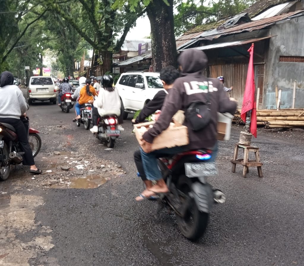 Bendera Partai sebagai tanda jalan rusak dj Jalan Gede Kota Malang, Jumat (8/3/2024). (blok-a/Satria Akbar Sigit)