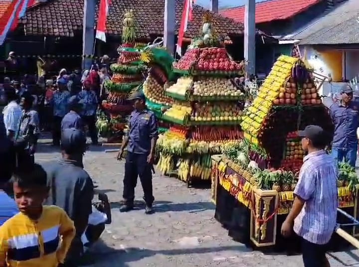 Arak-arakan tumpeng raksasa keliling kampung pada sedekah bumi Dusun Gumining, Desa Tambakrejo, Kecamatan Duduksampeyan, Kabupaten Gresik.
