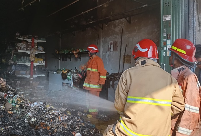 Anggota Damkarla Kabupaten Gresik saat melakukan pemadaman di Toko Budi Snack Desa Sembayat, Kecamatan Manyar, Kabupaten Gresik.