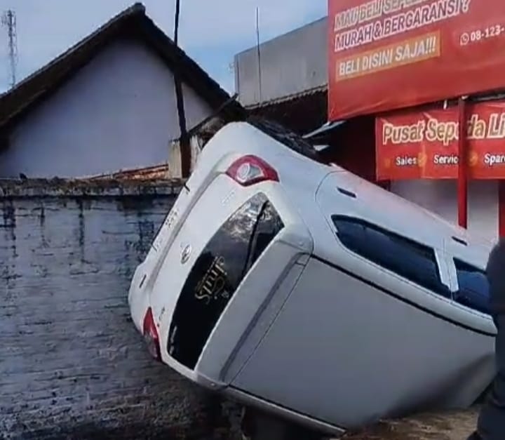 Kondisi mobil Daihatsu Ayla putih yang terbalik di parit Jalan Raya Genteng-Rogojampi, Kecamatan Genteng, Banyuwangi, Selasa (5/11/2024).(blok-a.com/Kuryanto)