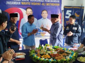 Wahyu Hidayat menerima potongan tumpeng pertama dari Mantan Bupati Rendra Kresna dalam acara HUT ke-13 Partai Nasdem (blok-a.com / Yogga Ardiawan)
