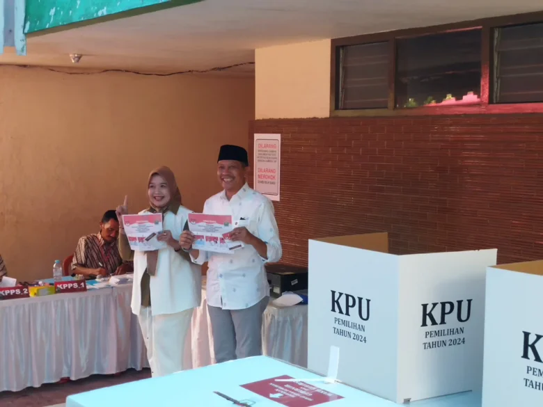 Wahyu Hidayat beserta istri saat memberikan suara di TPS, Rabu (27/11/2024) (blok-a/Yogga Ardiawan)