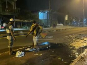 Warga sedang mengurug jalan nasional yang berlubang.(blok-a.com/Syahrul Wijaya)