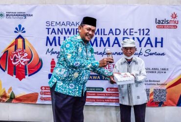 Sekretaris PCM Krembangan, Kota Surabaya, Mochammad Yusuf saat menyalurkan nasi kotak bergizi kepada masyarakat dhuafa. (Foto: Bintang)