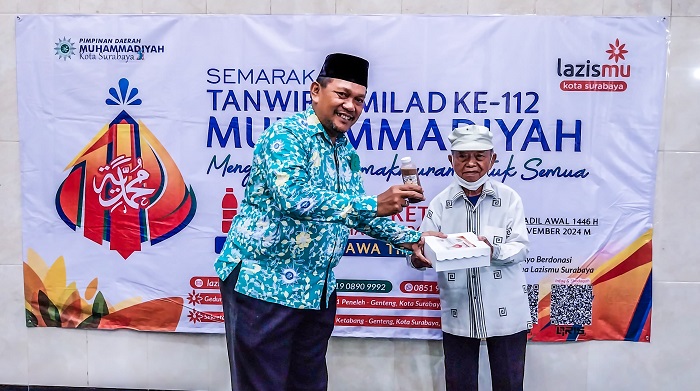 Sekretaris PCM Krembangan, Kota Surabaya, Mochammad Yusuf saat menyalurkan nasi kotak bergizi kepada masyarakat dhuafa. (Foto: Bintang)