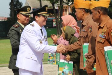 Pj Bupati Bojonegoro memberikan tali asih kepada pejuang veteran di upacara peringatan Hari Pahlawan di Alun-Alun Bojonegoro, Minggu (10/11/2024).
