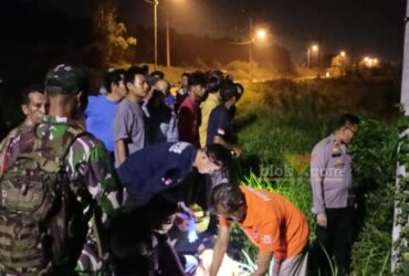 Petugas kepolisian dan inafis saat olah TKP sebuah parit di samping jalan Dusun Tempel, Desa Kedungmungal, Kecamatan Pungging, Selasa (26/11/2024).(blok-a.com/Syahrul Wijaya)