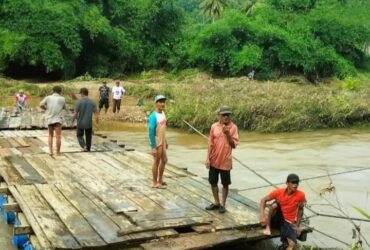 Caption : Perangkat Desa Sarongan, Kecamatan Pesanggaran bersama warga benahi tali penahan jembatan kayu yang terputus akibat banjir, Sabtu (30/11/2024)(blok-a.com/Kuryanto)