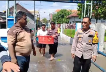 Anggota Polsek Jombang berikan bantuan kepada korban bencana banjir.(blok-a.com/Syahrul Wijaya)