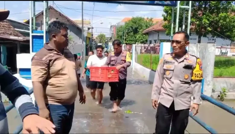Anggota Polsek Jombang berikan bantuan kepada korban bencana banjir.(blok-a.com/Syahrul Wijaya)