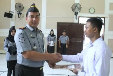 Kepala Rutan Kelas IIB Situbondo, Rudi Kristiawan (kiri) saat menyerahkan surat tanda remisi khusus natal kepada WBP Nasrani, Rabu (25/12/2024).