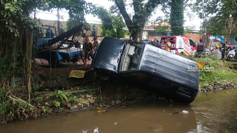 Mobil Isuzu Panther dievakuasi dengan dua mobil derek dari sungai depan SMA Negeri 6 Malang, Senin (16/12/2024) (blok-a/Andik Agus)