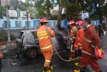 Pemadaman mobil mahasiswa yang terbakar di depan SMPN 6 Kota Malang, Sabtu (7/12/2024).