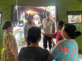 Anggota polres Mojokerto kota memberikan obat-obatan dan vitamin kepada warga di posko penyelamatan.(blok-a.com/Syahrul Wijaya)