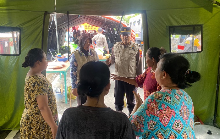 Anggota polres Mojokerto kota memberikan obat-obatan dan vitamin kepada warga di posko penyelamatan.(blok-a.com/Syahrul Wijaya)