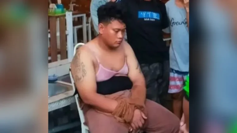 Pelaku pencuri kotak amal berinisial MPR memakai busana perempuan saat diamankan warga dan anggota Polsek Manyar (blok-a.com/Ivan)