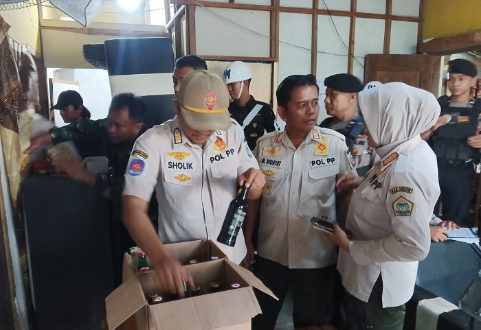 Petugas gabungan saat mengamankan puluhan botol miras saat razia di warung kopi dan Cafe di Jalur Pantura, Gresik.(Istimewa)