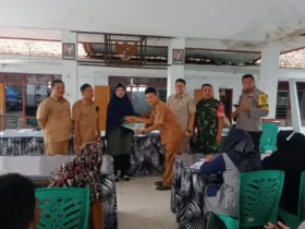Kepala Desa Paowan Surya Dharma bersama petugas Kantor BPN Situbondo, menyerahkan sertipikat tanah program PTSL kepada perwakilan warga Paowan di Kantor Desa Paowan. (blok-a.com/cik)