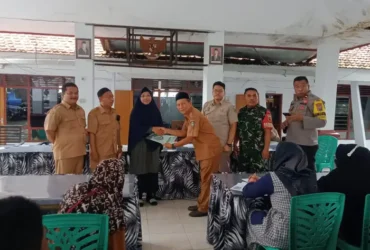 Kepala Desa Paowan Surya Dharma bersama petugas Kantor BPN Situbondo, menyerahkan sertipikat tanah program PTSL kepada perwakilan warga Paowan di Kantor Desa Paowan. (blok-a.com/cik)