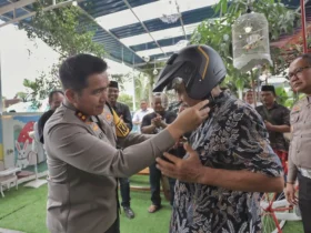 FOTO : Kapolres Blitar AKBP Arif Fazlurrahman memasangkan helm kepada tokoh perguruan silat di Kabupaten Blitar. (blok-a.com/Fajar)