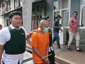 Tersangka yang aniaya anak tirinya digelandang ke Mapolres Mojokerto Kota.(blok-a.com/Syahrul Wijaya)
