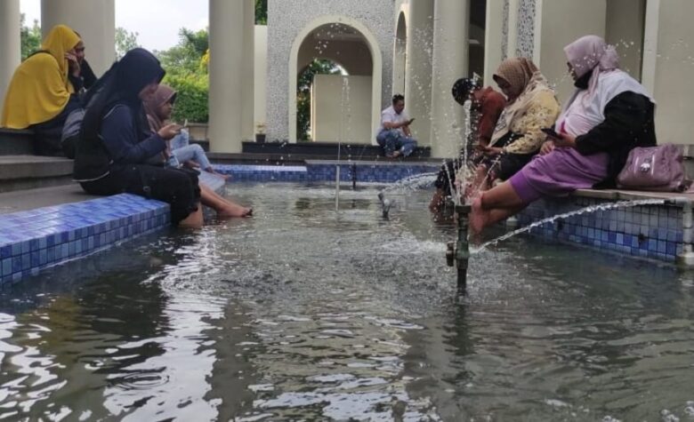 Teks foto : Para pengunjung Masjid KH Ahmad Dahlan Bunder, Gresik menikmati relaksasi terapi ikan.(istimewa)