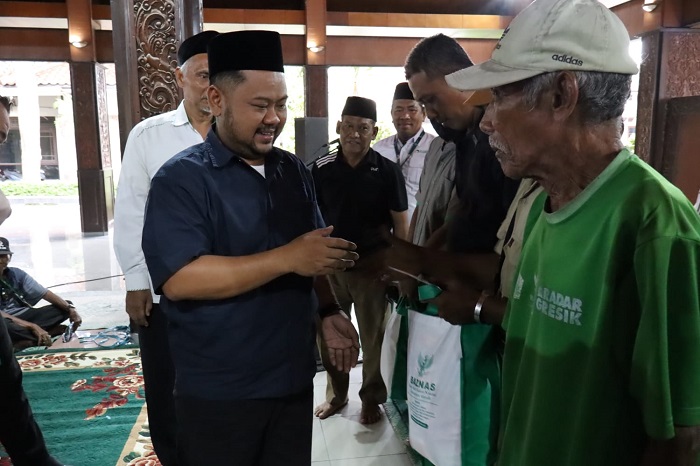 Bupati Gresik, Fandi Akhmad Yani saat menyalurkan paket sembako kepada tukang ojol, tukang becak dan Loper koran.(Ist)