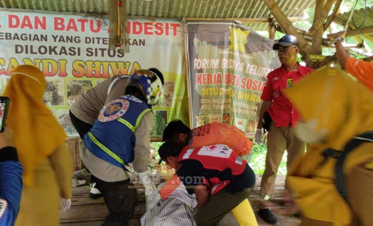 Petugas kepolisian dan PMI sedang melakukan evakuasi korban gantung diri di Trowulan.(blok-a.com/Syahrul Wijaya)
