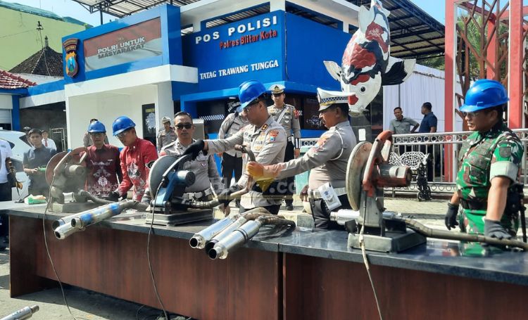Kapolres Blitar Kota, AKBP Titus Yudho Uli bersama Forpimda secara simbolis memotong knalpot brong dengan mesin gerinda. (blok-a.com/Fajar)