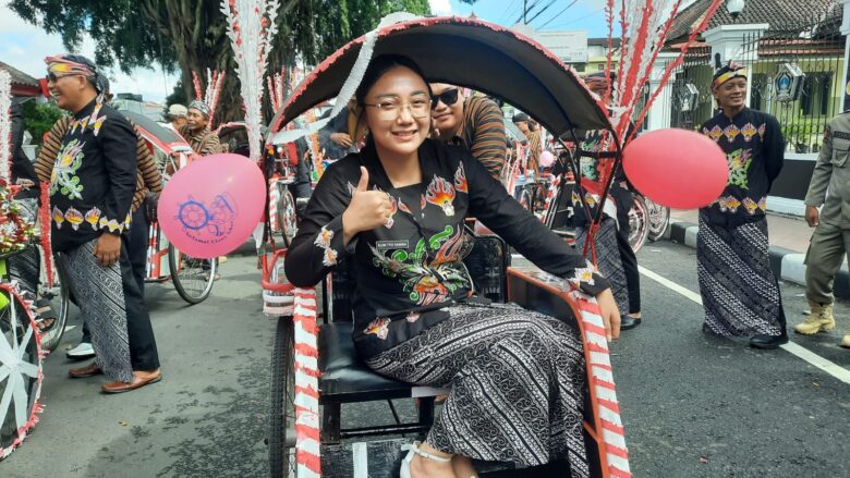 FOTO : Wakil Wali Kota Blitar, Elim Tyu Samba naik becak mengikuti Kirab Gunungan Lima menuju Makam Bung Karno. (blok-a.com/Fajar)