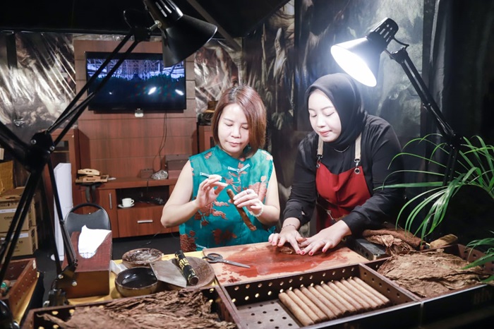 Salah seorang peserta JKCI 2025 mencoba membuat cerutu, Jumat malam (11/7/2025). (Foto: Diskominfo Jember for blok-a.com)