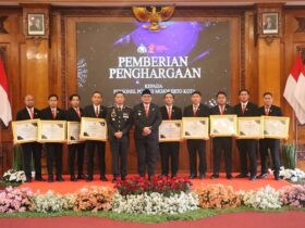 Wakil Wali Kota Mojokerto menyerahkan penghargaan kepada polisi usai upacara HUT Bhayangkara ke -79.(blok-a.com/Syahrul Wijaya)