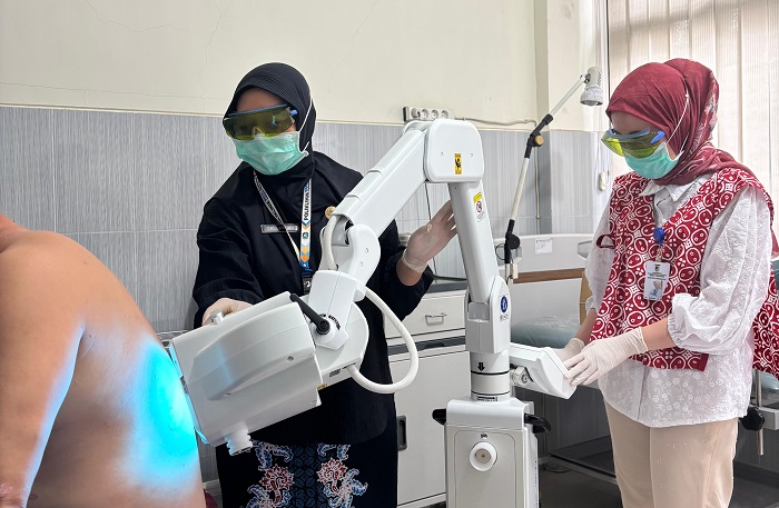 Petugas medis Poli Kulit RSUD Genteng, saat memberikan terapi dengan menggunakan alat Phototherapy UV 308 dengan Excimer Filter.(dok Humas RSUD)